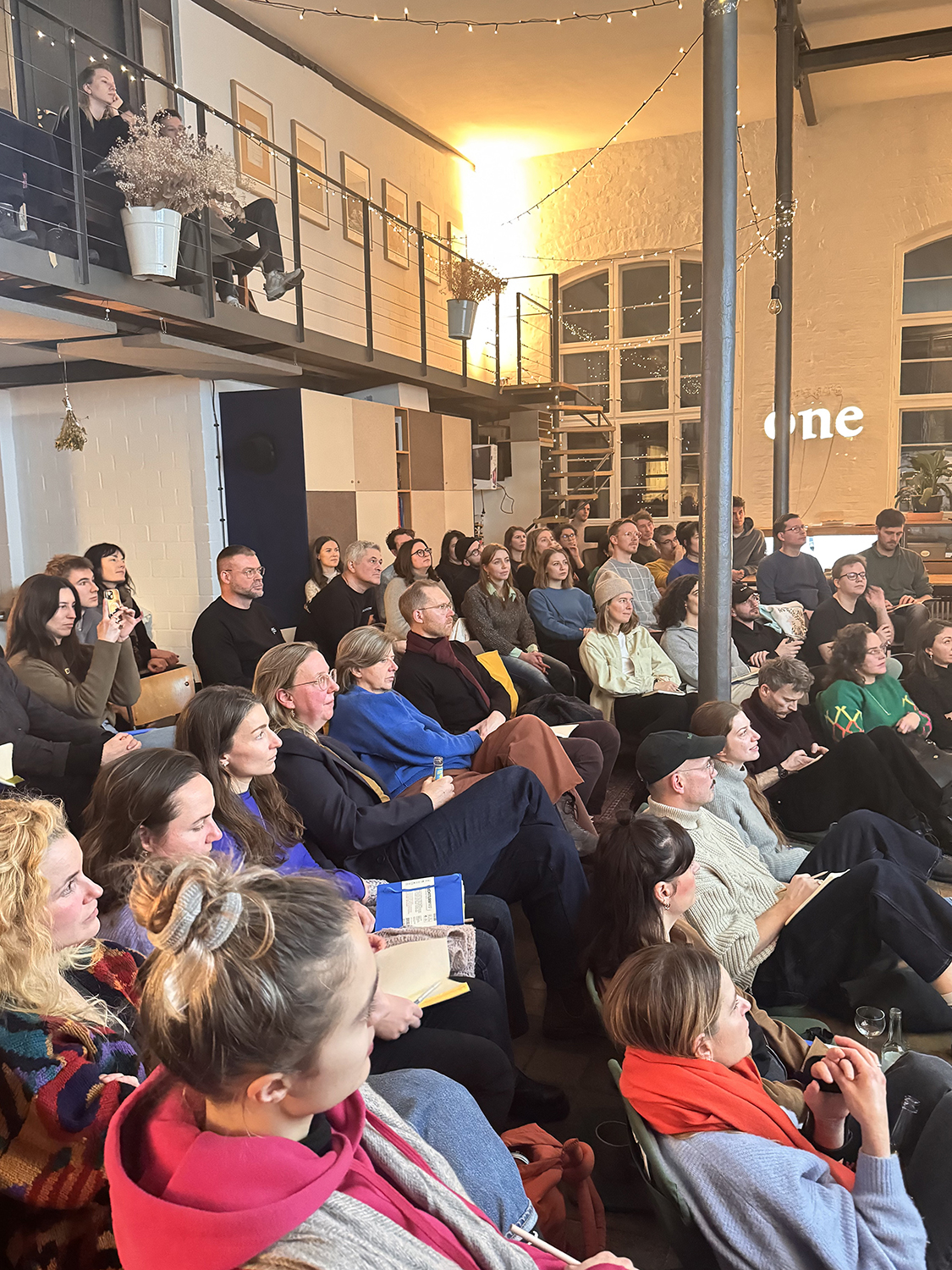 Publikum mit Notizbüchern, Blick zur Bühne